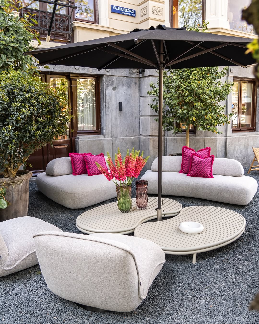 eichholtz outdoor sofa with umberalla and little table